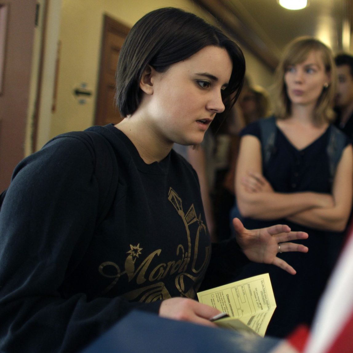 College student Paige McLoughlin, 19, of Parker, Colo., talks over paperwork with an electoral official before voting in the general election, at a polling station serving the local student population on the campus of the University of Colorado, in Boulder, Colo., Tuesday, Nov. 6, 2012. (AP Photo/Brennan Linsley)