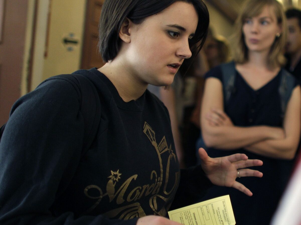 College student Paige McLoughlin, 19, of Parker, Colo., talks over paperwork with an electoral official before voting in the general election, at a polling station serving the local student population on the campus of the University of Colorado, in Boulder, Colo., Tuesday, Nov. 6, 2012. (AP Photo/Brennan Linsley)