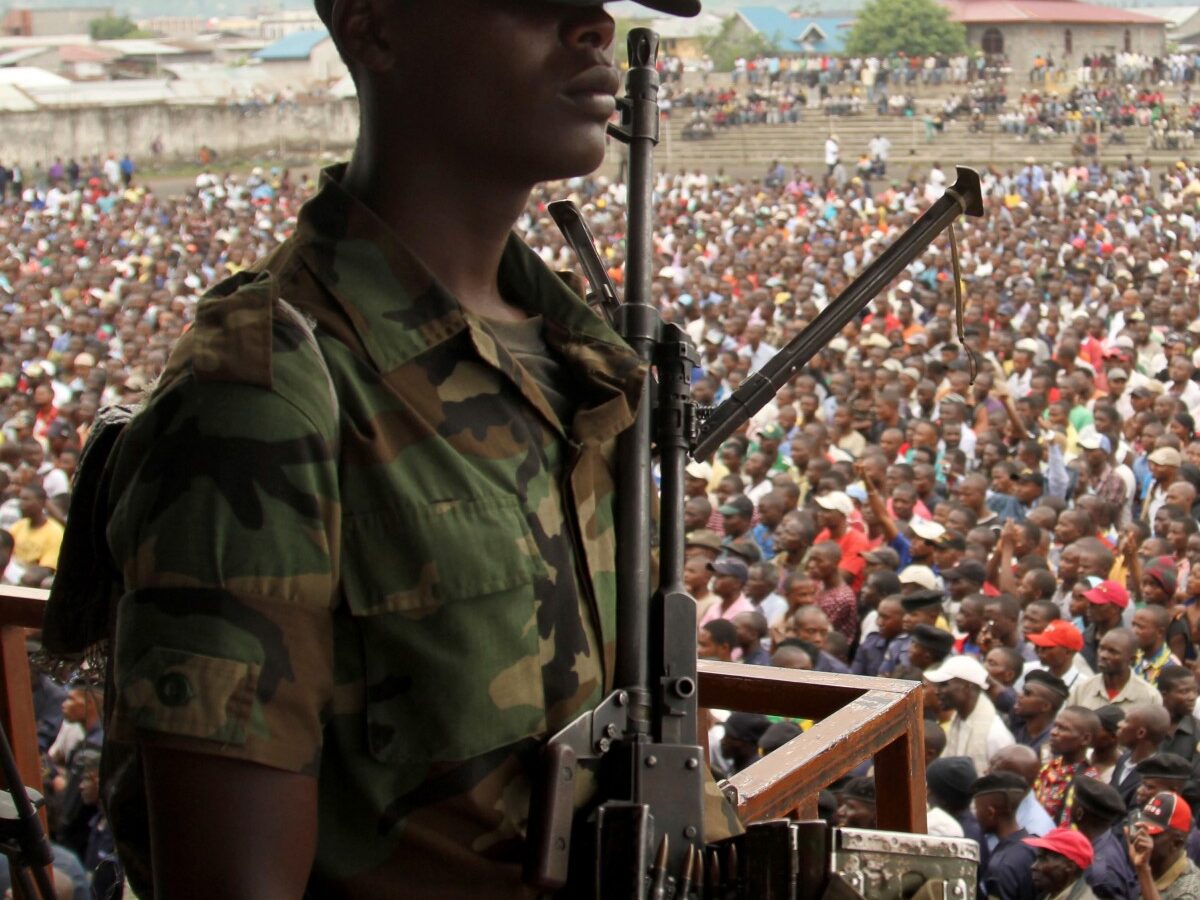 A soldier from the M23 rebel group looks on as thousands of Congolese people listen during an M23 rally, in Goma, eastern Congo, Wednesday, Nov. 21, 2012. (AP Photo/Marc Hofer)