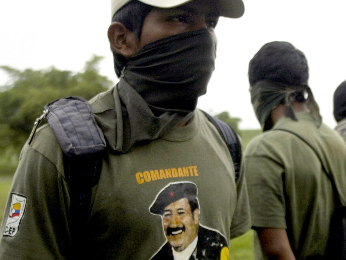 In this Monday, June 23, 2008, file photo, a member of the Revolutionary Armed Forces of Colombia, FARC stands with his face covered at a military base in Cali, Colombia. (AP Photo/Christian Escobar Mora)