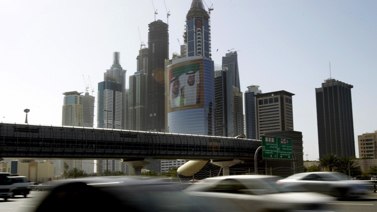 This March 9, 2011, file photo, shows a large image of Sheik Mohammed bin Rashid Al-Maktoum, UAE Prime Minister and ruler of Dubai, rear left, and Sheik Khalifa bin Zayed Al-Nahyan, UAE President, right, on a tower at Internet City, as cars pass drive on Sheikh Zayed's highway in Dubai, United Arab Emirates. (AP Photo/Kamran Jebreili, File)