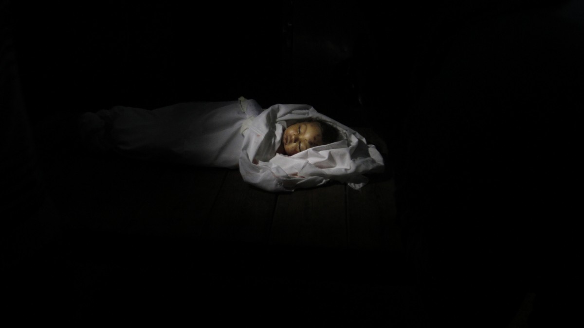 The body of 10-month-old Palestinian infant Haneen Tafesh lies in the morgue of Shifa hospital in Gaza City, Thursday, Nov. 15, 2012. According to hospital reports, Tafesh died from wounds caused by an earlier Israeli strike. (AP Photo/Hatem Moussa)
