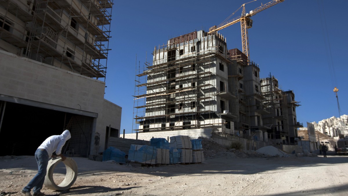 In this Nov. 2, 2011 file photo, a construction worker works at a site of a new housing unit in the east Jerusalem neighborhood of Har Homa. (AP Photo/Sebastian Scheiner, File)