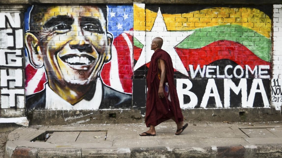 In this Sunday, Nov. 11, 2012 photo, a monk walks past a a wall painting created by graffiti artists to welcome U.S. President Barack Obama on a street in Yangon, Myanmar. Obama is scheduled to visit Myanmar later this week, the first visit by a U.S. president to the the one-time pariah nation, which is emerging from decades of military rule. (AP Photo/Aung Pyae)