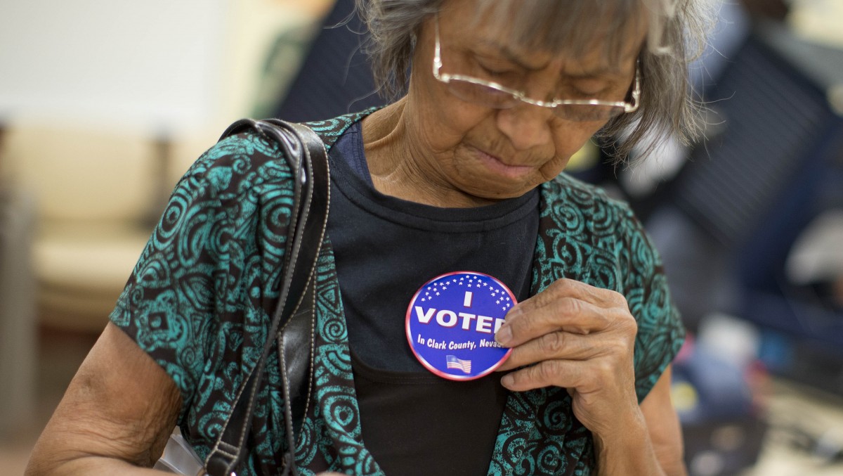 Aida Castillo places a sticker on her blouse indicating that she had voted during the early voting period, Saturday, Oct. 20, 2012, in Las Vegas. (AP Photo/Julie Jacobson)