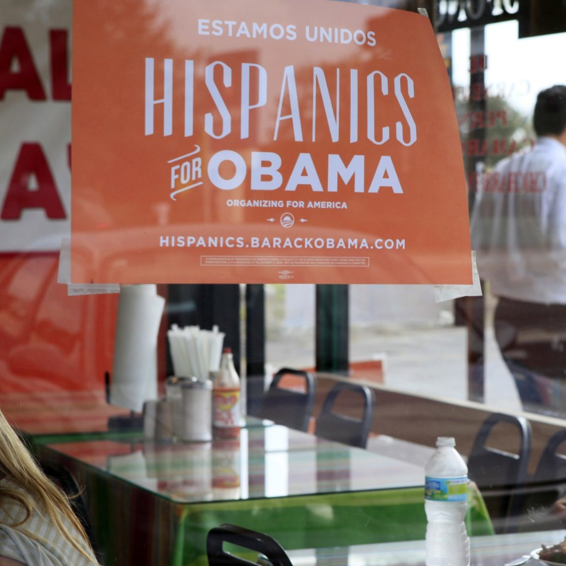 In this Oct. 26, 2012, file photo, Spanish language election campaign signs promoting President Barack Obama hang on the windows at Lechonera El Barrio Restaurant in Orlando, Fla. (AP Photo/Julie Fletcher)