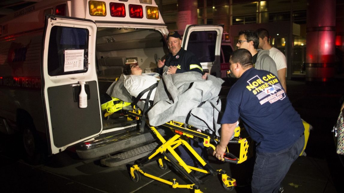 Medical workers assist a patient into an ambulance during an evacuation of New York University Tisch Hospital, after its backup generator failed when the power was knocked out by a superstorm, Monday, Oct. 29, 2012, in New York. (AP Photo/John Minchillo)