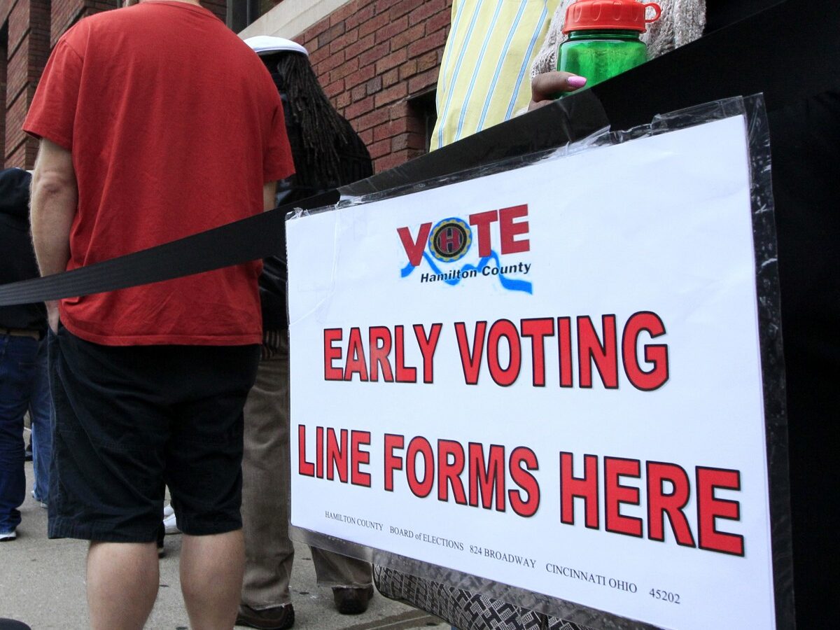 In this Oct. 2, 2012 file photo, voters stand in line outside the Hamilton County Board of Elections just before it opened for early voting, in Cincinnati. (AP Photo/Al Behrman, File)