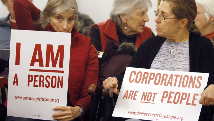 In this Jan. 20, 2012 photo, people hold signs during a gathering on the anniversary of the Citizens United decision in Montpelier, Vt. First, it was the Vermont senator with socialist leanings. (AP Photo/Toby Talbot)