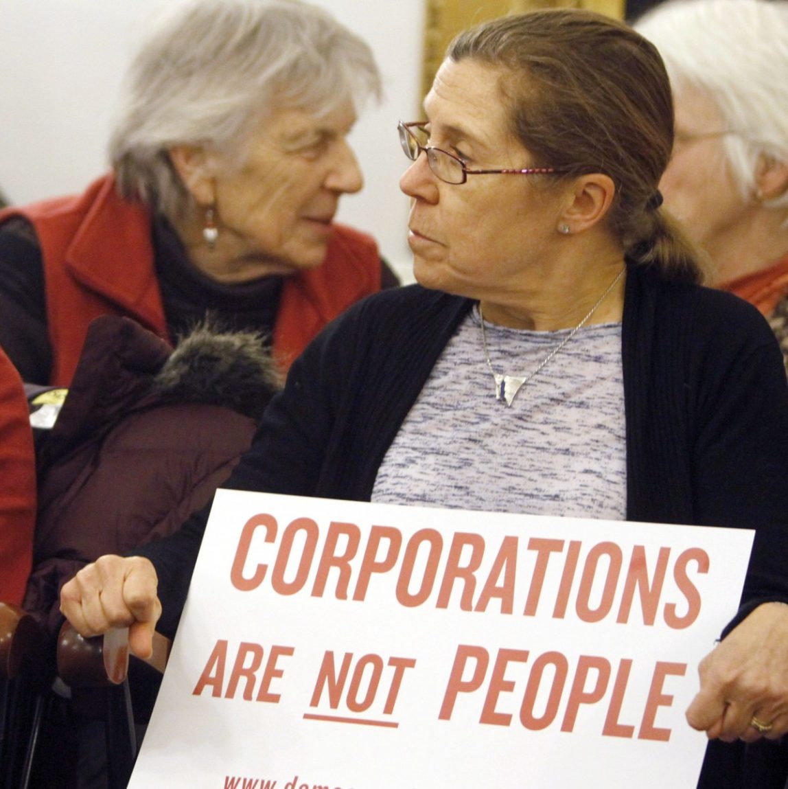 In this Jan. 20, 2012 photo, people hold signs during a gathering on the anniversary of the Citizens United decision in Montpelier, Vt. (AP Photo/Toby Talbot)