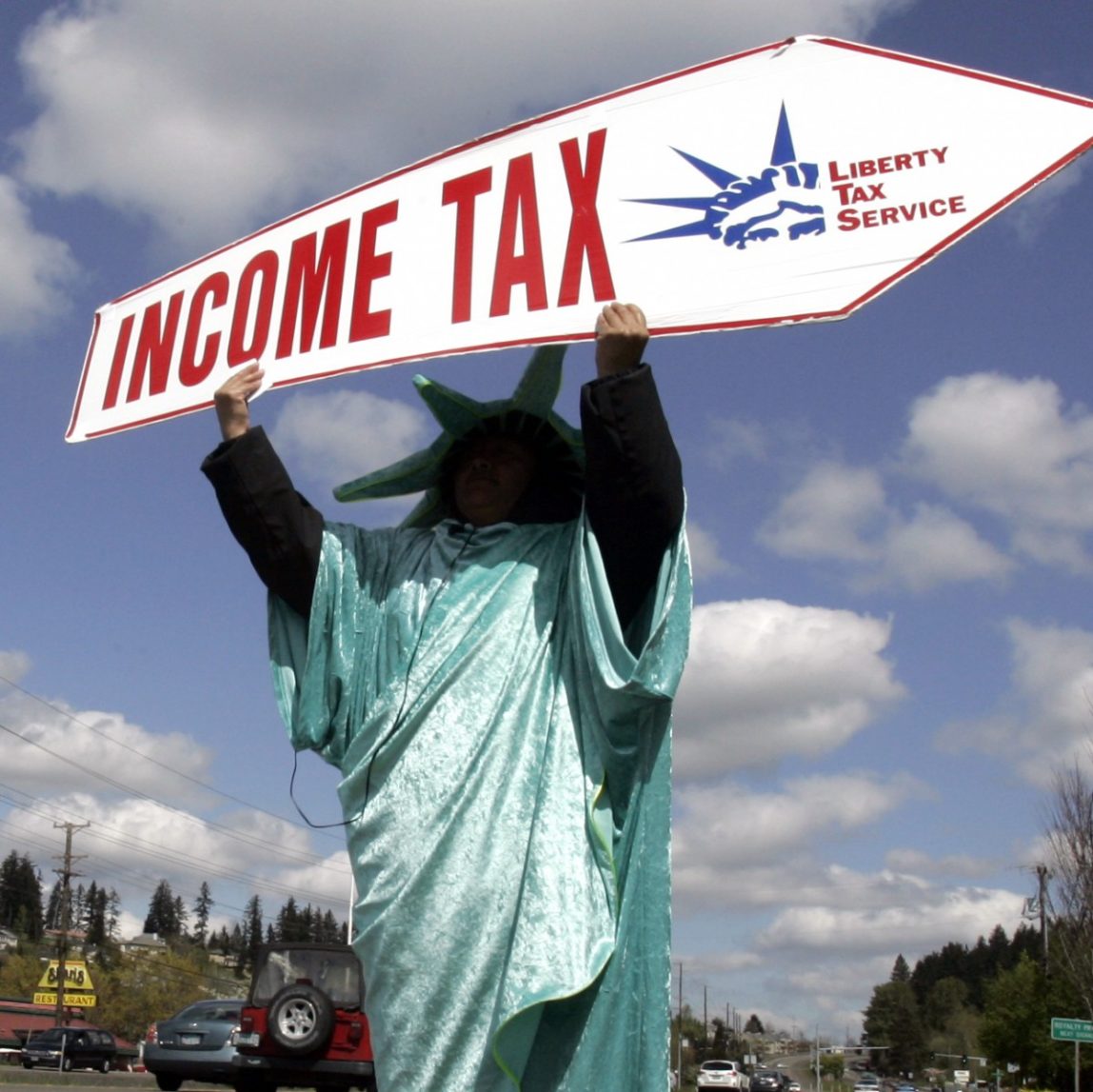 In this Thursday, April 15, 2010, file photo, Sonia Joaquin holds a sign to remind passing motorists that Thursday is the deadline for taxes in Tigard, Ore. America's decision to re-elect President Barack Obama over Republican presidential candidate, former Massachusetts Gov. Mitt Romney will impact key sectors of the American economy. Upper-income Americans may face a tax increase, while Bush-era tax cuts could be extended for low- and middle-income Americans. (AP Photo/Don Ryan, File)