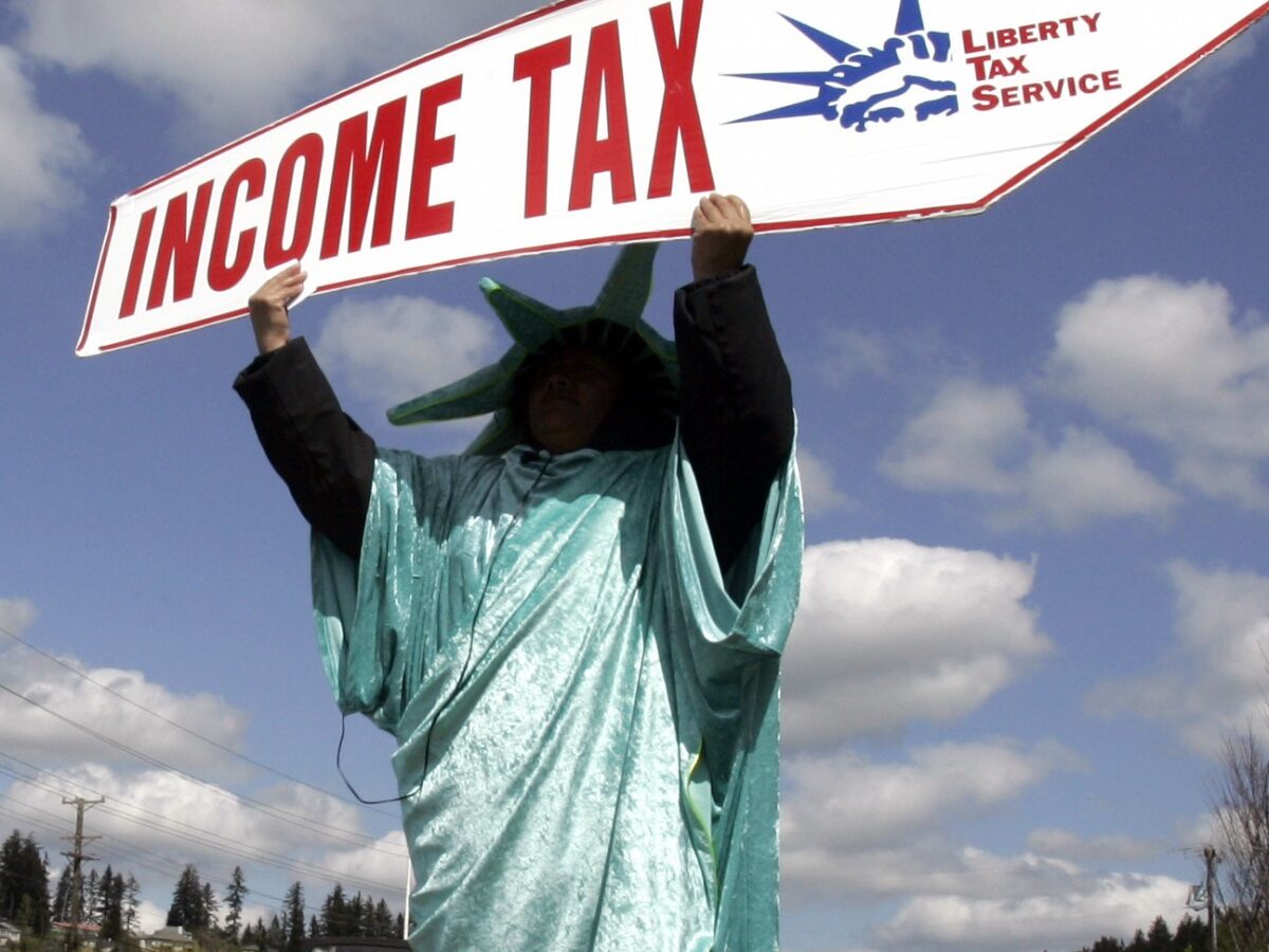 In this Thursday, April 15, 2010, file photo, Sonia Joaquin holds a sign to remind passing motorists that Thursday is the deadline for taxes in Tigard, Ore. America's decision to re-elect President Barack Obama over Republican presidential candidate, former Massachusetts Gov. Mitt Romney will impact key sectors of the American economy. Upper-income Americans may face a tax increase, while Bush-era tax cuts could be extended for low- and middle-income Americans. (AP Photo/Don Ryan, File)