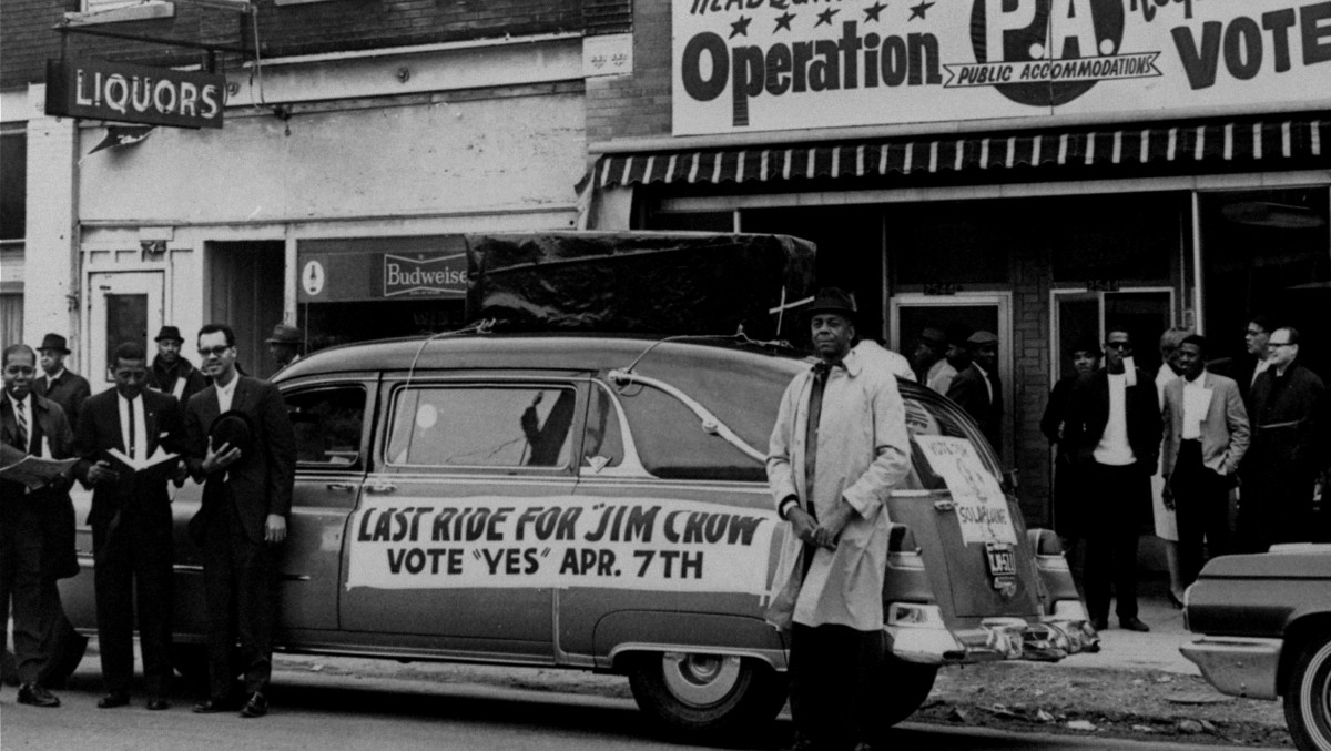 A hearse with a casket mounted on its top and a sign reading "Last ride for Jim Crow; vote 'yes' Apr. 7th," is parked in front of headquarters for workers favoring approval of Kansas City's Public Accommodations ordinance that was being voted on in a referendum election April 7, 1964. (AP Photo)