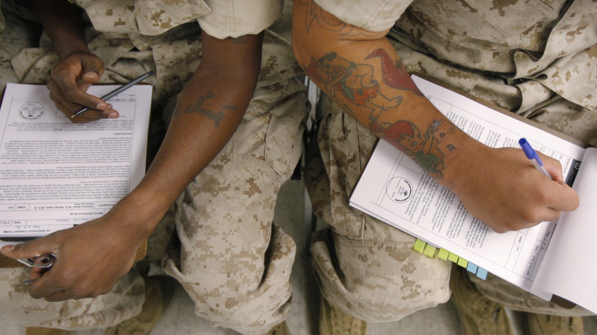 In this Sept. 29, 2009 file photo, U.S. Marines fill out research consent forms before taking psychological tests at the Marine Corps Air Ground Combat Center in Twentynine Palms, Calif. in a program testing hundreds of Marines and soldiers before they ship out to search for clues that might help predict who is most susceptible to post-traumatic stress disorder. (AP Photo/Jae C. Hong)