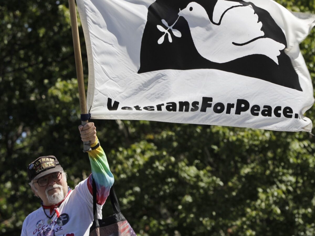 An activist associated with the Occupy Wall Street holds up a Veterans for Peace flag during a gathering of the movement in Washington Square park, Saturday, Sept. 15, 2012 in New York. (AP Photo/Mary Altaffer)
