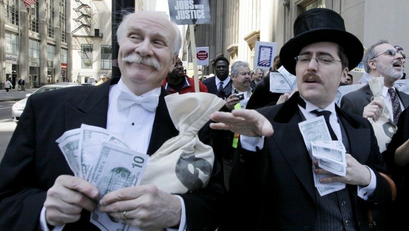 Protesters Richard Hanzel, left, Brendan Hutt, and Richard Shavzin, right, of the Screen Actors Guild, dressed as wall street bankers, march from Goldman Sachs' office to a rally in Federal Plaza demanding Wall Street reform, Wednesday, April 28, 2010, in Chicago. (AP Photo/M. Spencer Green)