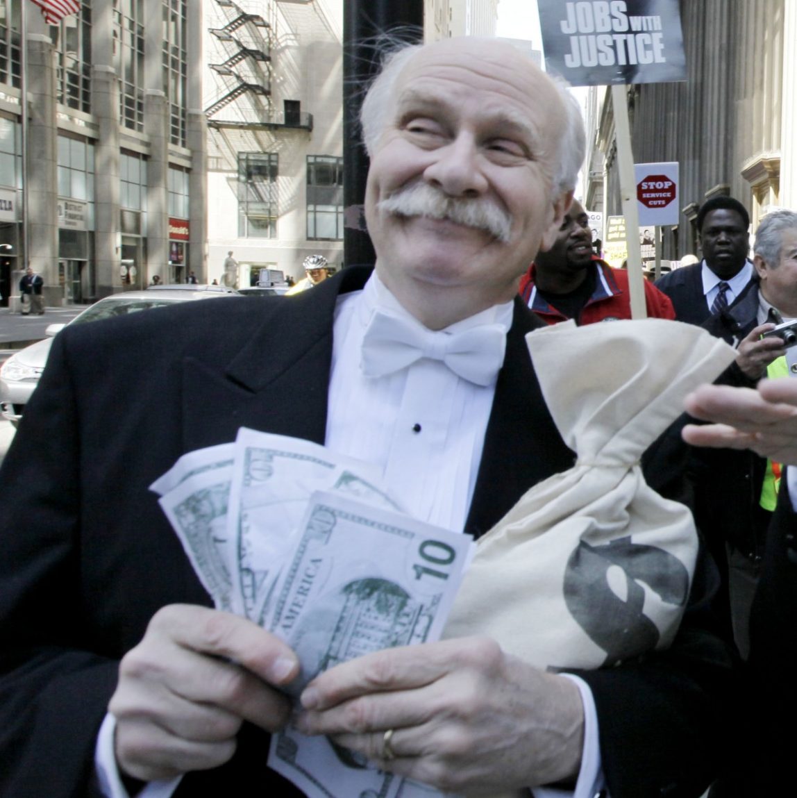 Protesters Richard Hanzel, left, Brendan Hutt, and Richard Shavzin, right, of the Screen Actors Guild, dressed as wall street bankers, march from Goldman Sachs' office to a rally in Federal Plaza demanding Wall Street reform, Wednesday, April 28, 2010, in Chicago. (AP Photo/M. Spencer Green)