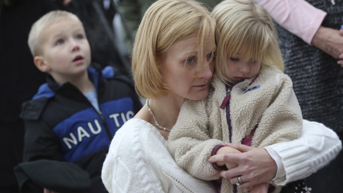 Barbara Wells of Shelton, Conn., holds her daughter Olivia, 3, as she pays her respects Monday, Dec. 17, 2012 at one of the makeshift memorials for the victims of the Sandy Hook Elementary School shooting in Newtown, Conn. (AP Photo/Mary Altaffer)