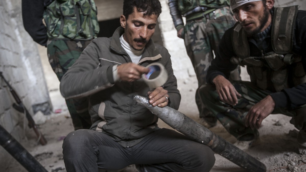 In this Saturday, Nov. 17, 2012 photo, Syrian rebel fighters prepare to fire a homemade rocket as they carry out a coordinated attack by hundreds of rebel fighters on a Syrian air force compound during heavy clashes on the outskirts of Aleppo, Syria. (AP Photo/Narciso Contreras)