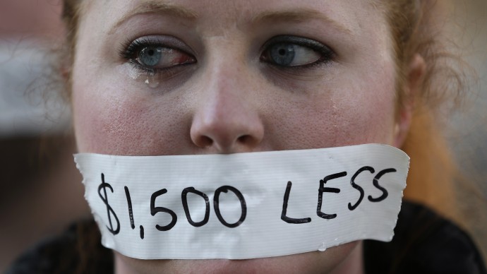 A silent protester cries while wearing a sticker over her mouth signifying the loss in wages from the right-to-work law in Lansing, Mich., Wednesday, Dec. 12, 2012. (AP Photo/Paul Sancya)
