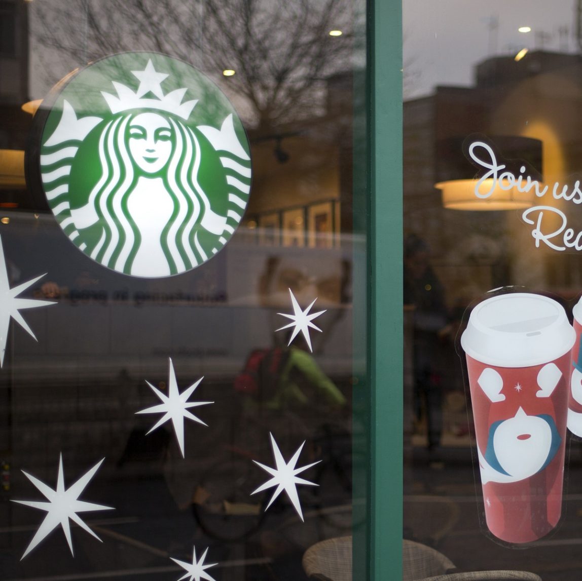 A man walks out of a Starbucks coffee cafe holding a drink in west London, Monday, Dec. 3, 2012. (AP Photo/Alastair Grant)