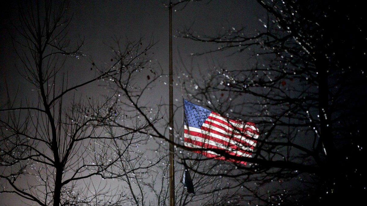 A U.S. flag flies at half staff outside the Newtown High School before President Barack Obama was scheduled to attend a memorial for the victims of the Sandy Hook Elementary School shooting, Sunday, Dec. 16, 2012, in Newtown, Conn. (AP Photo/David Goldman)