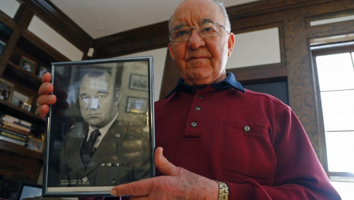 In this Dec. 13, 2012 photo, Howard Rowell shows a photo of himself when he retired from the Air Force Reserve at his home in Columbia, S.C. (AP Photo/Chuck Burton)
