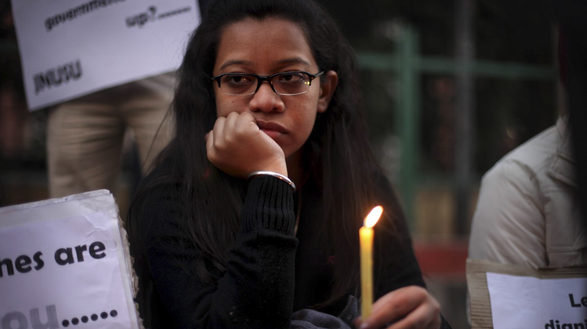 An woman watches as she participates in a candlelight vigil for a rape victim. (AP Photo/Altaf Qadri)