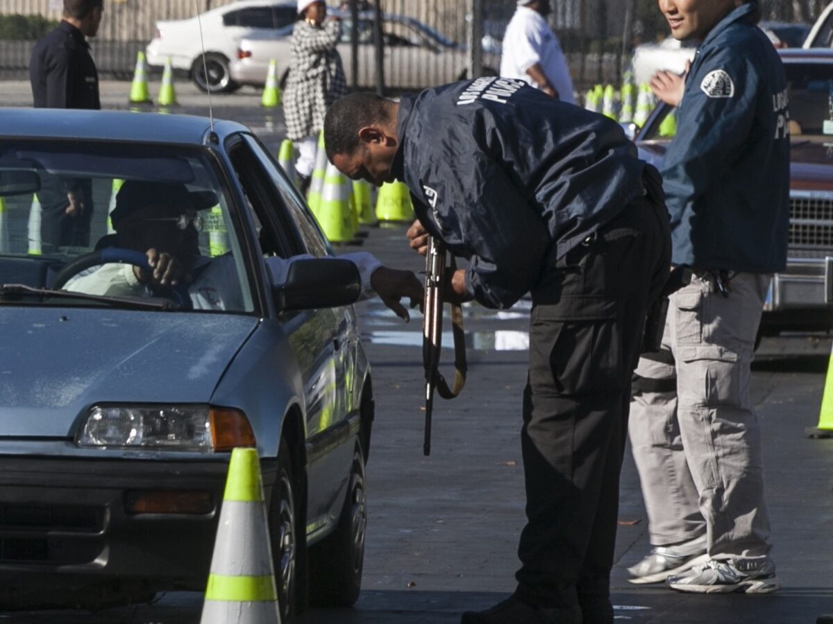 Motorists wait inside their cars to drop guns to waiting Los Angeles Police officials at the LA Memorial Sports Arena in Los Angeles Wednesday, Dec. 26, 2012. (AP Photo/Damian Dovarganes)