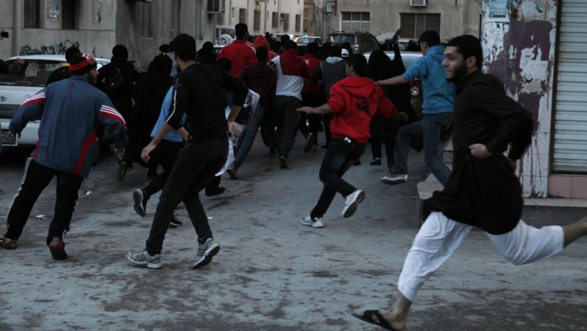 Bahraini anti-government protesters run from riot police, unseen, run in Manama, Bahrain, Monday, Dec.17, 2012. (AP Photo/Hasan Jamali)