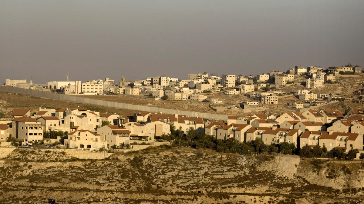 In this July 29, 2009 file photo, the Jewish neighborhood of Pisgat Zeev in east Jerusalem is seen with the Shuafat refugee camp, background, and Israel's separation barrier running between them. (AP Photo/Sebastian Scheiner, File)
