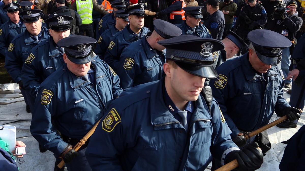 Michigan State Police march out of the area where the Americans for Prosperity tent was taken down by protesters, Tuesday, Dec. 11, 2012 in Lansing, Mich. Many angry with the right-to-work bill took their anger out with the Americans for Prosperity who support the bill. A couple people were trapped inside but made their way out quickly. The tent coming down caused the Michigan State Police to come out to take control of the situation. Michigan lawmakers gave final approval Tuesday to right-to-work legislation, dealing a devastating and once-unthinkable defeat to organized labor in a state that has been a bastion of the movement for generations. (AP Photo/Detroit Free Press, Eric Seals)