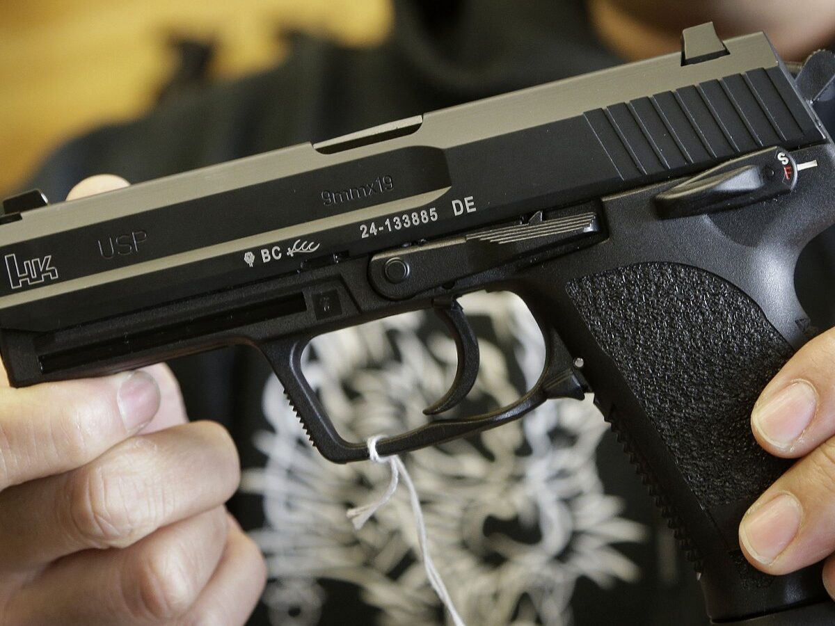 General manager Steve Alcairo holds an HK USP 9mm handgun while being interviewed at High Bridge Arms Inc. in San Francisco, Wednesday, Dec. 19, 2012. (AP Photo/Jeff Chiu)