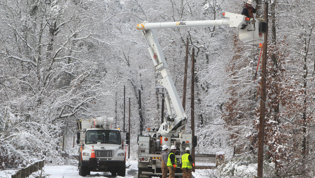 An Entergy Arkansas Inc., crew works to restore power to customers on Whittington Avenue near the entrance to Hot Springs National Park, Thursday, Dec. 27, 2012, in Hot Springs, Ark. (AP Photo/The Sentinel-Record, Richard Rasmussen)