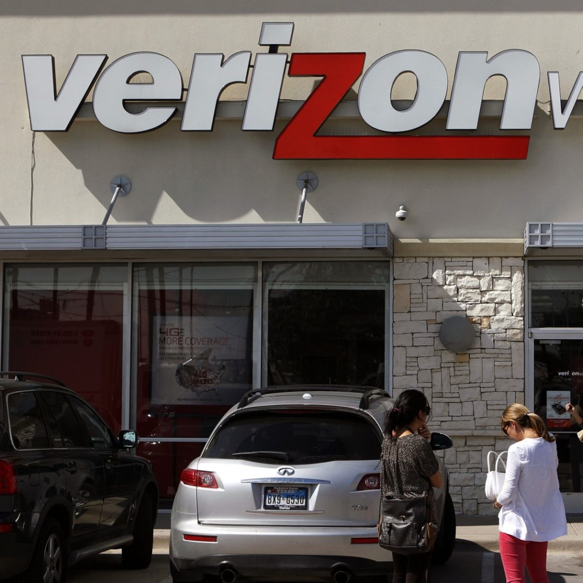 In this Wednesday, Oct. 17, 2012, file photo, customers walk into a Verizon Wireless store in Dallas. (AP Photo/LM Otero, File)