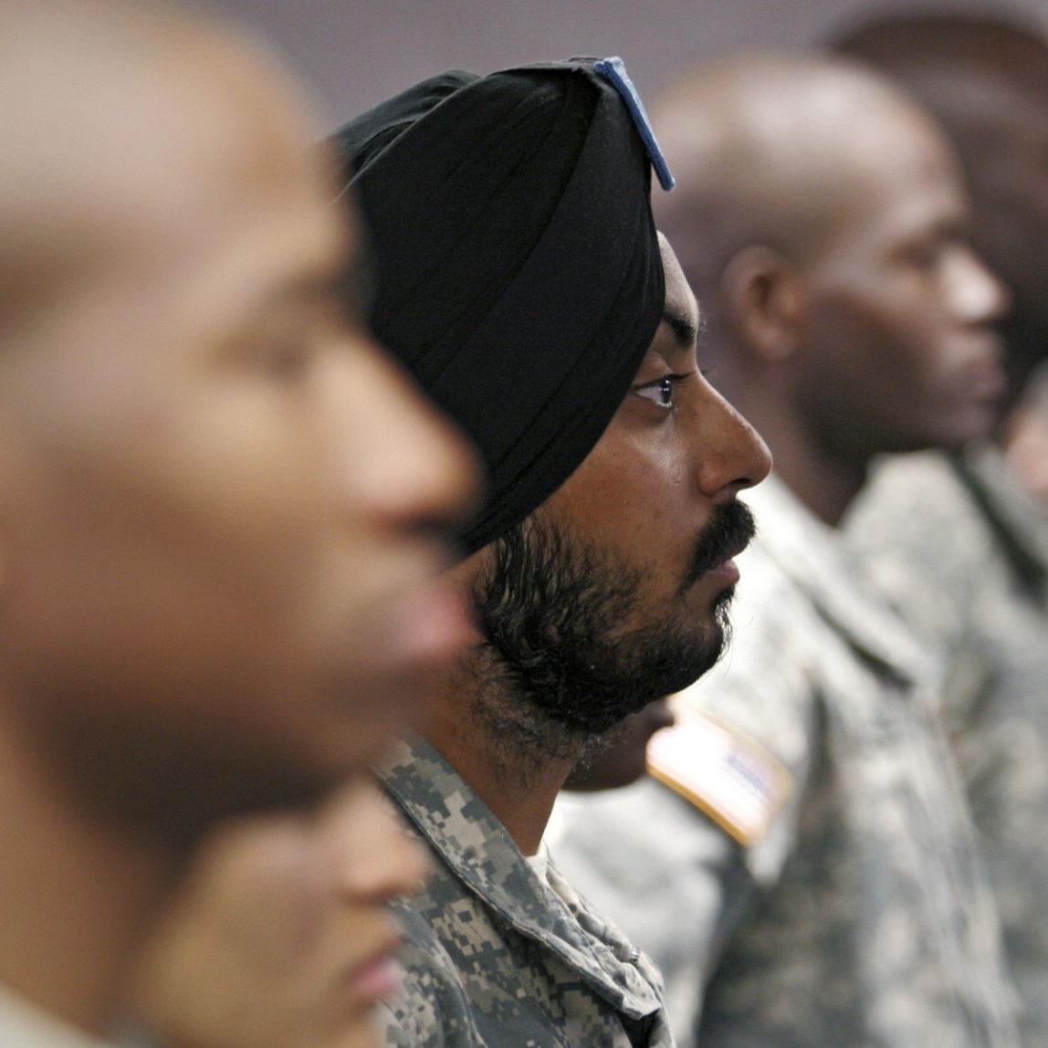 U.S. Army Spc. Simran Lamba, center, the first enlisted Soldier to be granted a religious accommodation for his Sikh articles of faith since 1984, stands in formation with fellow soldiers before taking the oath of citizenship, prior to his graduation from basic training at Fort Jackson, S.C., Wednesday, Nov. 10, 2010. (AP Photo/Brett Flashnick)