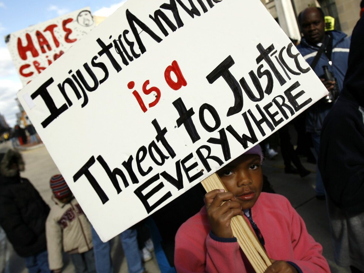 A child carries a sign as she marches around the Justice Department in Washington, Friday, Nov. 16, 2007, during the "March Against Hate Crimes." (AP Photo/Jose Luis Magana)