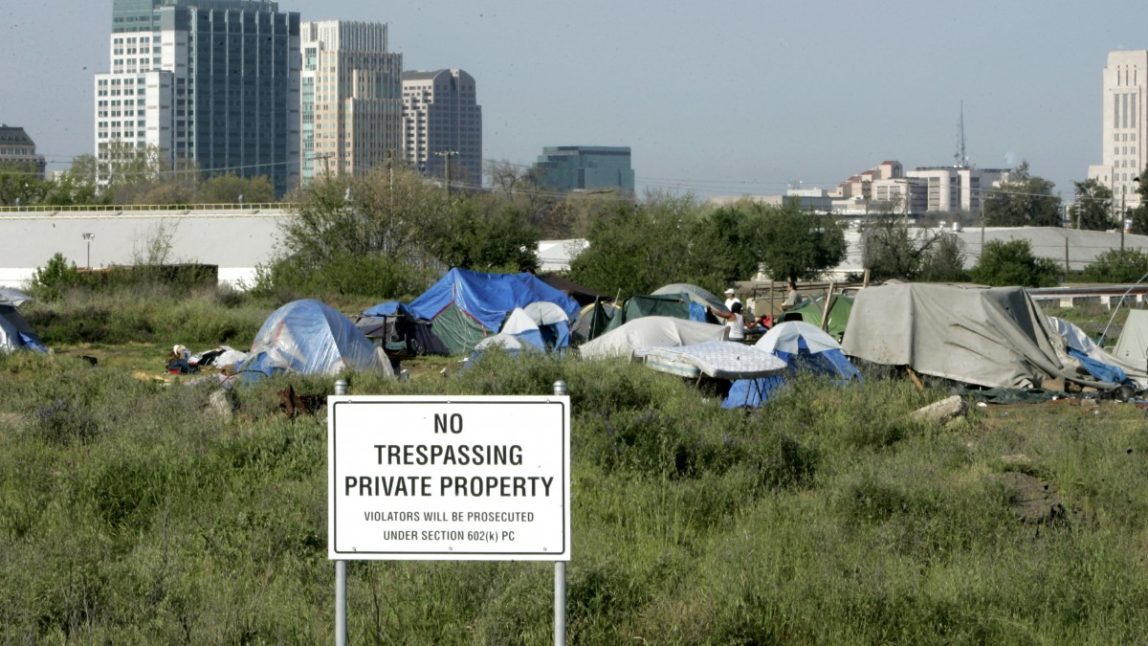 In this April 13, 2009 file photo, a "No trespassing" sign is seen at the edge of a homeless camp in Sacramento, Calif. (AP Photo/Rich Pedroncelli, File)