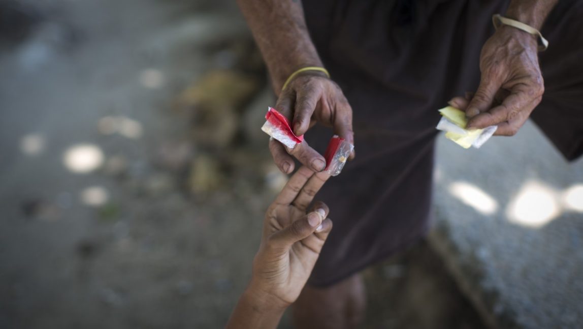 In this photo taken Dec. 21, 2012, former soldier Bobo, right, buys crack, right hand, and cocaine on the street in Rio de Janeiro, Brazil. (AP Photo/Felipe Dana)