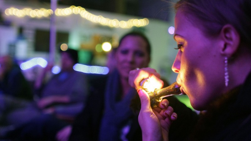 Rachel Schaefer of Denver smokes marijuana on the official opening night of Club 64, a marijuana-specific social club, where a New Year's Eve party was held, in Denver, Monday Dec. 31, 2012. (AP Photo/Brennan Linsley)