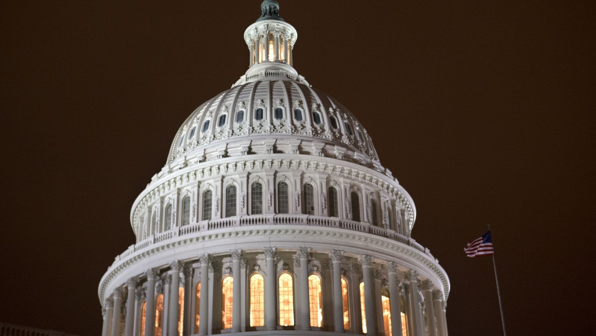 As an evening haze lights the sky with a reddish glow, the lights of the U.S. Capitol burn into the night as the House continues to work on the "fiscal cliff" legislation proposed by the Senate, in Washington, on Tuesday, Jan. 1, 2013. (AP Photo/Jacquelyn Martin)
