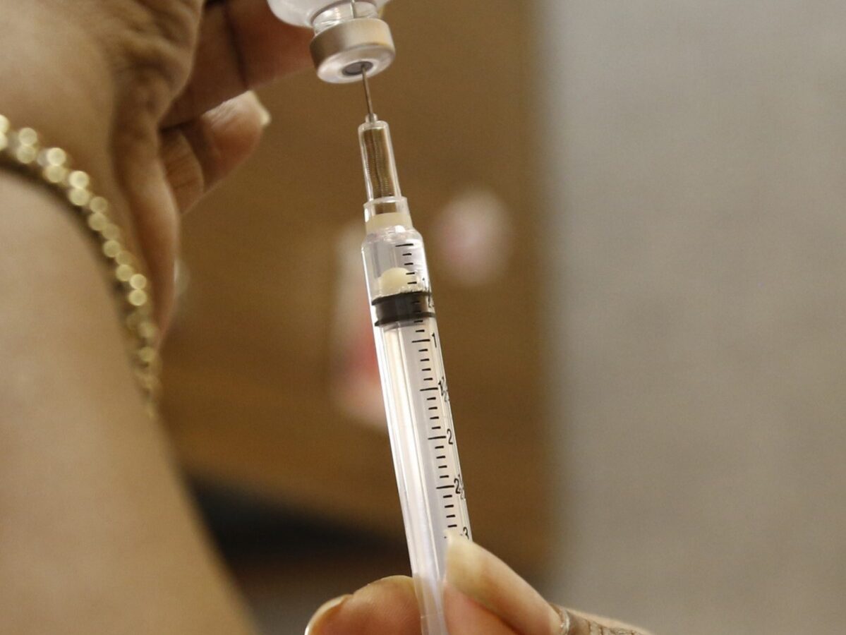 A public health nurse demonstrates drawing flu vaccine from a bottle at the Oklahoma City-County Health Department in Oklahoma City, Thursday, Jan. 10, 2013. (AP Photo/Sue Ogrocki)