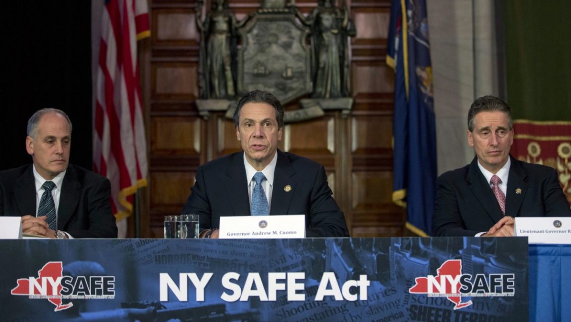 New York Gov. Andrew Cuomo, center, speaks during a news conference announcing an agreement with legislative leaders on New York's Secure Ammunition and Firearms Enforcement Act in the Red Room at the Capitol on Monday, Jan. 14, 2013, in Albany, N.Y. Also pictured are Secretary to the Governor Larry Schwartz, left, and Lt. Gov. Robert Duffy. (AP Photo/Mike Groll)