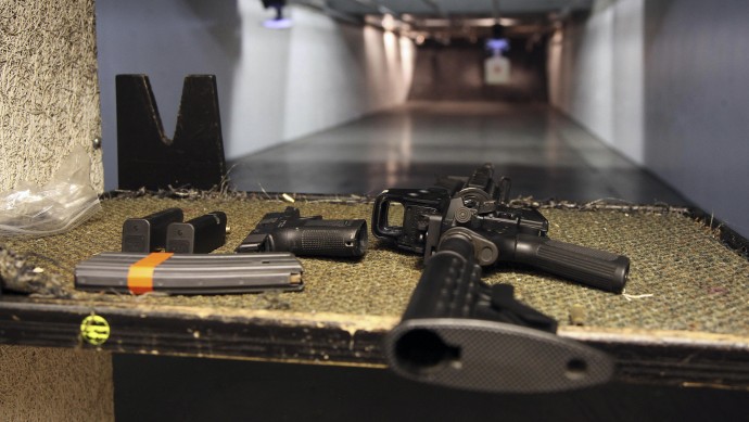 In this Jan. 4, 2013, photo, a rifle and a hand gun are displayed on the range of Sandy Springs Gun Club and Range, in Sandy Springs, Ga. (AP Photo/Robert Ray)