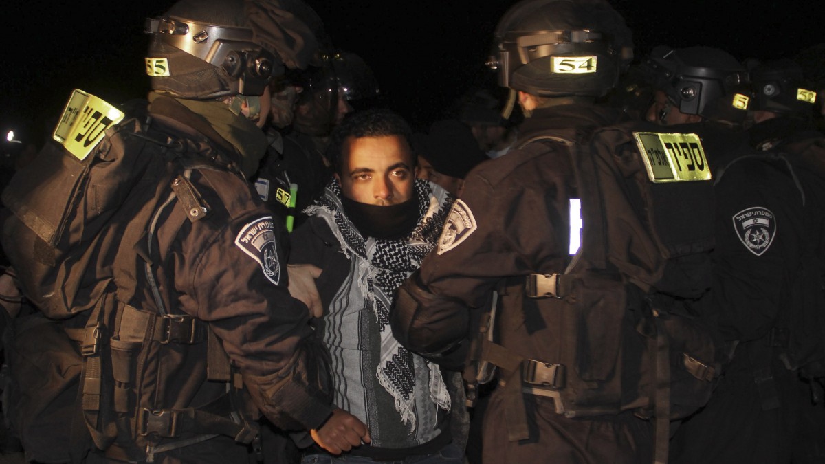 Israeli border police evict a Palestinian activist from an area known as E-1 near Jerusalem, Sunday, Jan 13, 2013. Palestinian activists erected tents in the area on Friday saying they wanted to "establish facts on the ground" to stop Israeli construction in the West Bank. (AP Photo/Nasser Shiyoukhi)