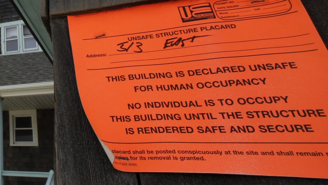 In this Jan. 3, 2013, file photo, an unsafe for human occupancy sticker is attached to a home that was severely damaged by Superstorm Sandy in Bay Head, N.J. (AP Photo/Mel Evans)