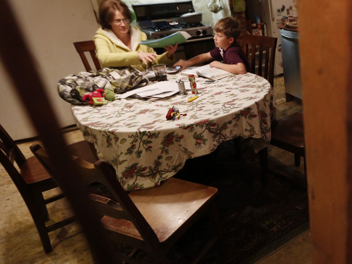 In this Thursday, Jan. 17, 2013 photo, seen through the beams of a gutted wall, Irene Sobolov, left, sits at a table while her 10-year-old son Joey Sobolov works on his fifth grade science homework in their home in Hoboken, N.J. (AP Photo/Julio Cortez)