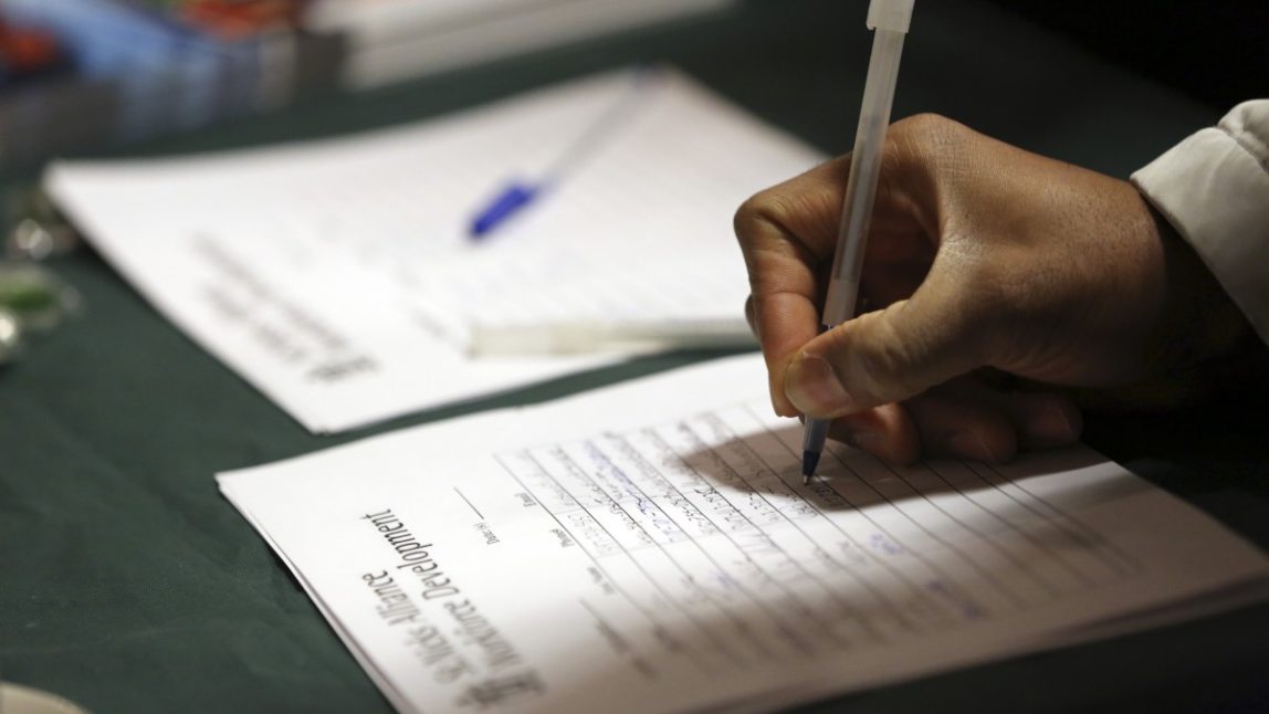 In this Wednesday, Dec. 12 2012 photo a job seeker leaves his contact information with a potential employer during a job fair in New York. (AP Photo/Mary Altaffer)