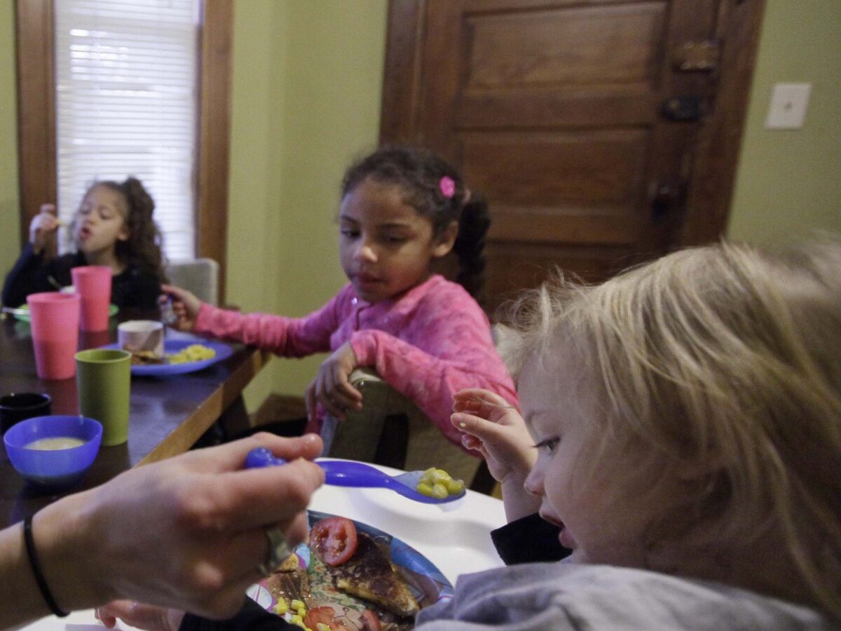 In this photo taken Nov. 23, 2009 in Chicago, Lisa Zilligen, 28, serves lunch to her three children, Miles, 20 months, Olivia 6, left, and Danielle, 8, in her home. (AP Photo/M. Spencer Green)