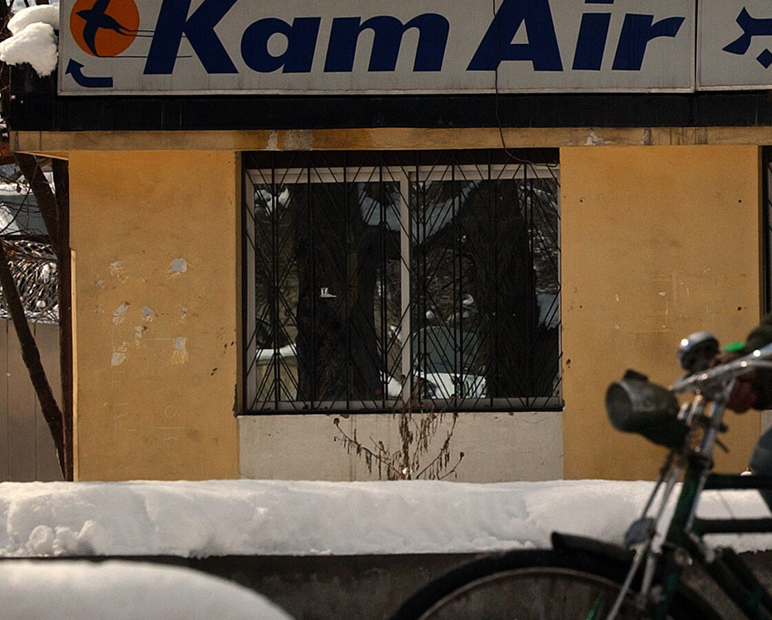 An Afghan man rides a bicycle as he pass by the Kam Air office in Kabul, Afghanistan on Friday Feb 4 2005. (AP Photo/Emilio Morenatti)